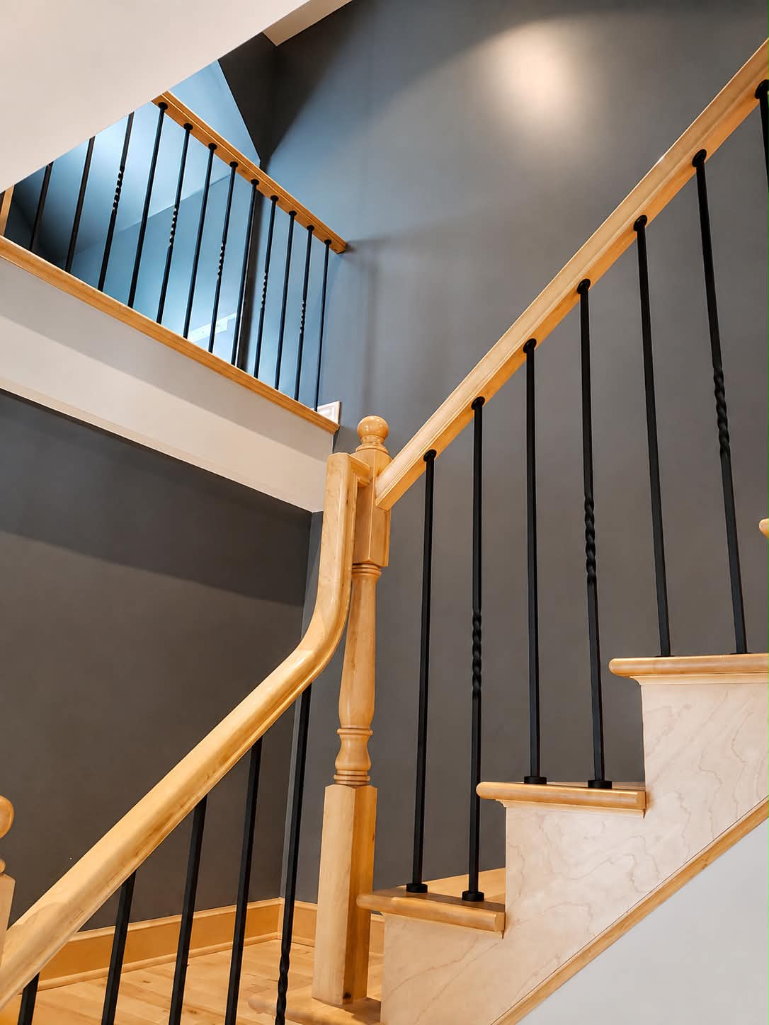 Escalier en bois avec murs gris foncé et rampes noires