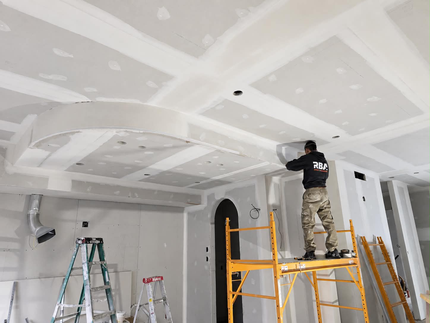 Artisan RBA travaillant sur un grand plafond de gypse