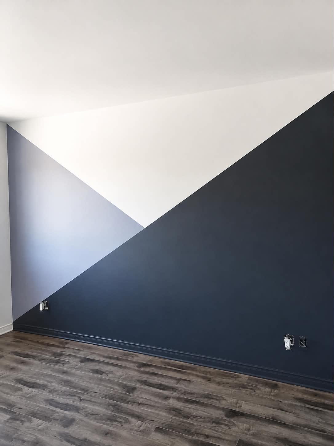 Mur accent peint en formes géométriques bleu foncé, gris et blanc